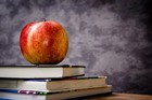 Apple sitting atop books on a table